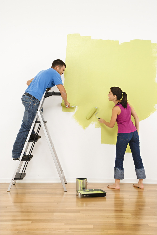 Two people painting a wall