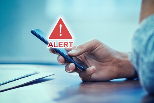 hand holding smartphone with Alert