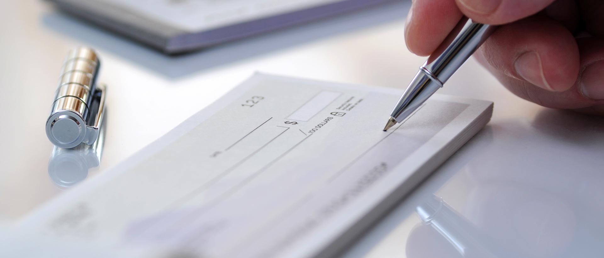 Closeup of a hand filling out a paper check