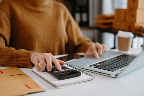 woman on computer and using calculator