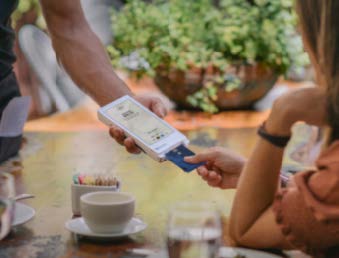 woman paying for lunch with her card on a merchant product
