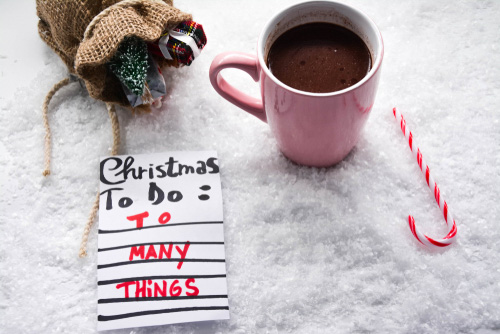 Christmas to do list with to many things. Hot cocoa, candy cane, burlap sack with tree and present with snow background